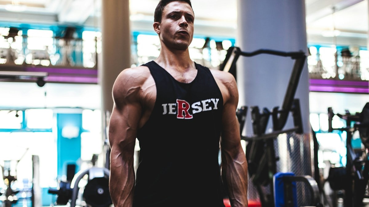 man in black tank top and gray pants